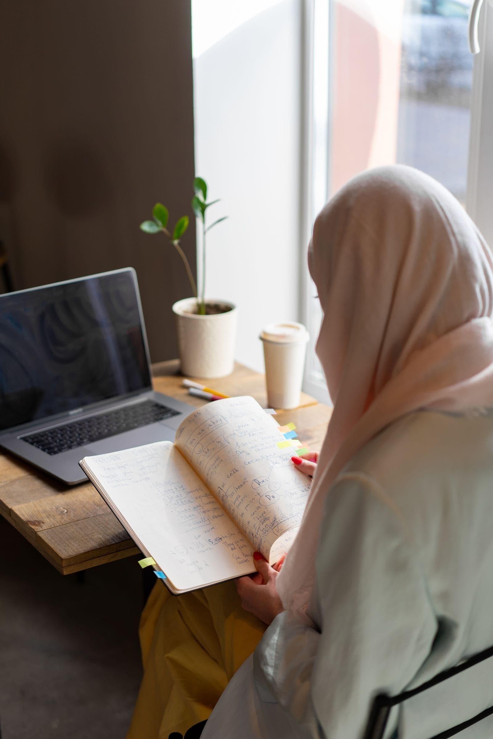 Learner with laptop and study notes